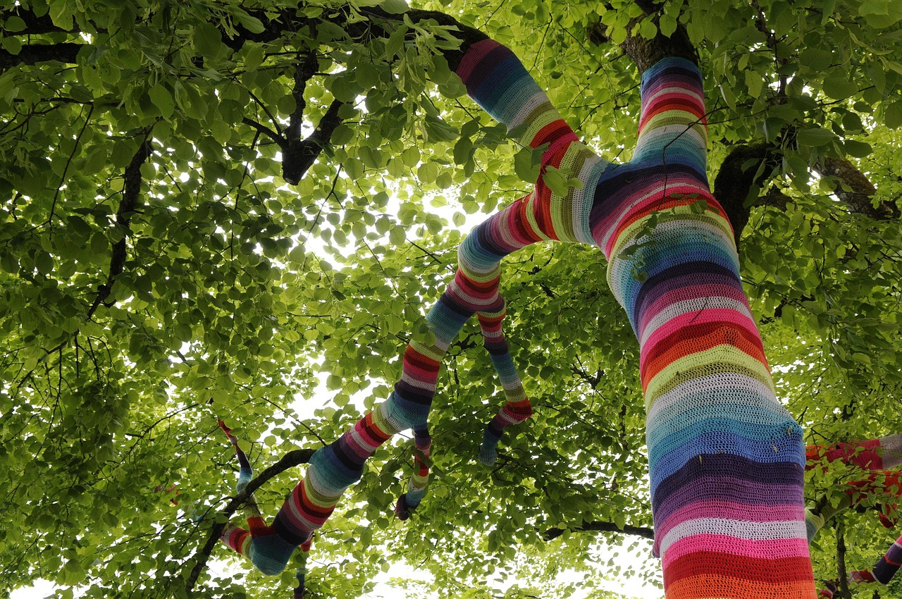 looking up into a tree canopy with colourful yarn around a tree trunk | The Superpower of the Wandering Mind | AI and copywriting | Jacky Fitt